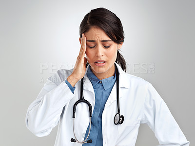 Buy stock photo Studio shot of a young doctor experiencing stress against a grey background