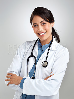 Buy stock photo Studio portrait of a confident young doctor posing against a grey background