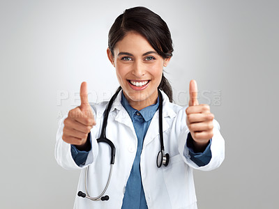 Buy stock photo Studio portrait of a young doctor showing thumbs up against a grey background