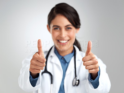 Buy stock photo Studio portrait of a young doctor showing thumbs up against a grey background
