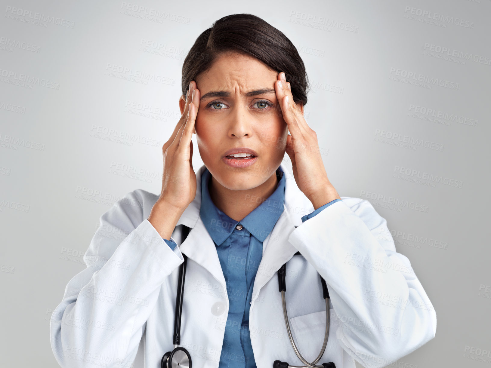 Buy stock photo Studio shot of a young doctor experiencing stress against a grey background