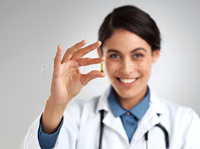 Buy stock photo Studio shot of a young doctor recommending medication against a grey background