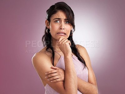 Buy stock photo Shot of a beautiful young woman  in disbelief with her arms folded and her hand resting against her chin on a pink background