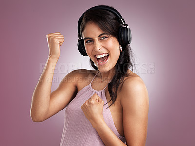 Buy stock photo Shot of a beautiful young cheerful woman celebrating while wearing headphones against a pink background