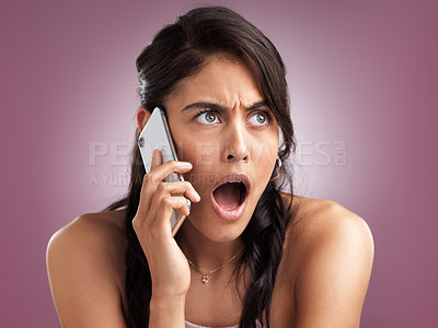 Buy stock photo Shot of a beautiful young woman looking shocked while talking on a mobile phone against a pink background