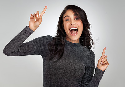 Buy stock photo Shot of a young woman looking cheerful while standing against a grey background