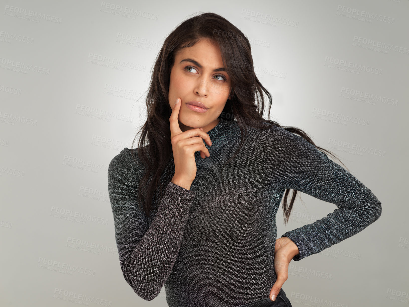 Buy stock photo Shot of a beautiful young woman looking thoughtful while standing against a white background