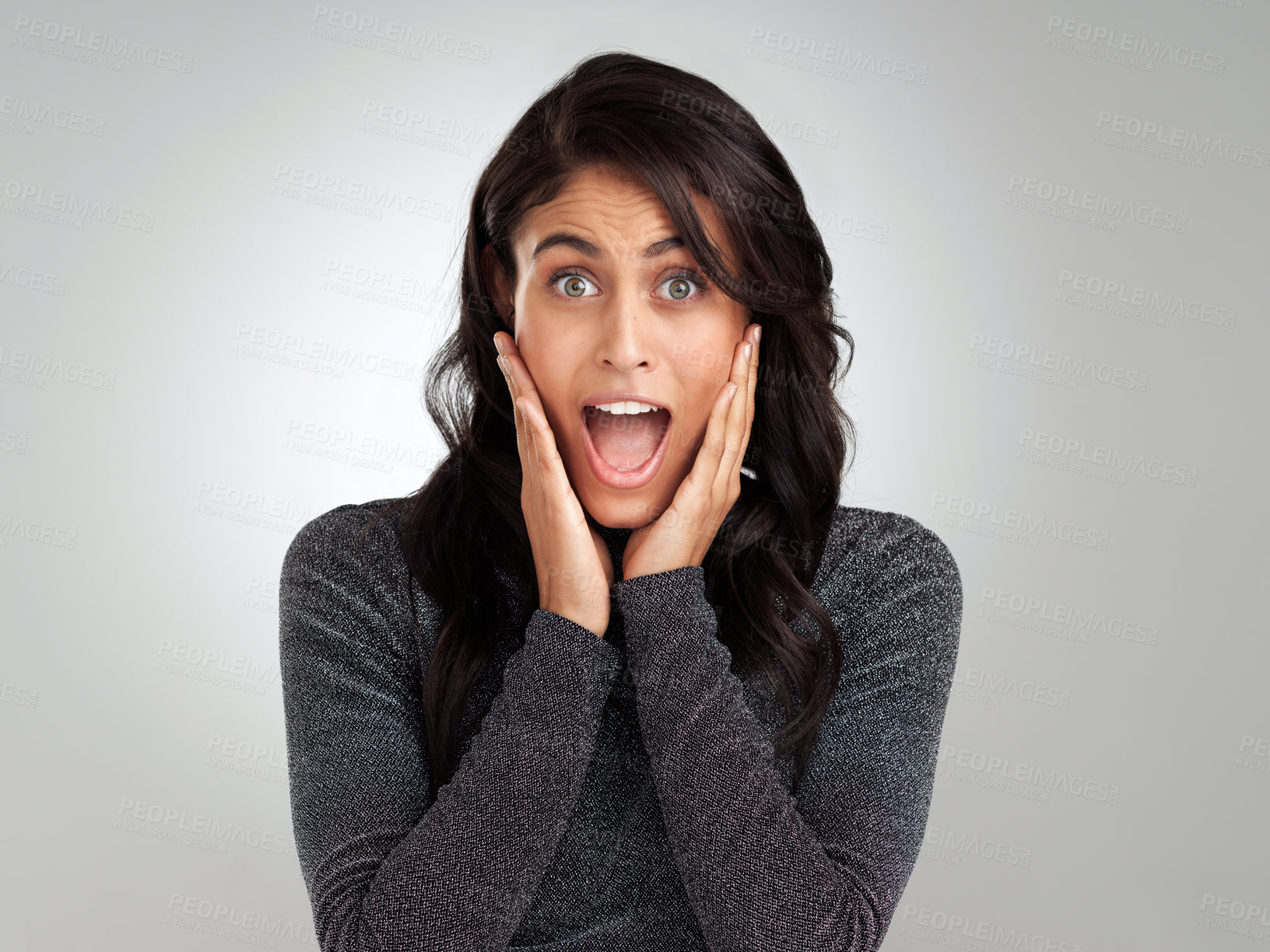 Buy stock photo Shot of a young woman looking surprised while posing against a white background