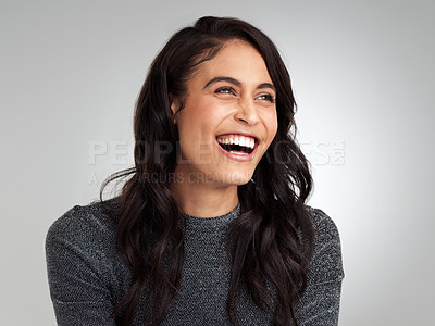 Buy stock photo Shot of a beautiful young woman laughing while standing against a grey background