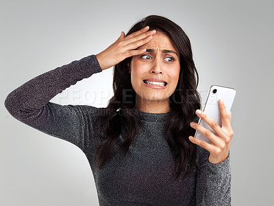 Buy stock photo Shot of a woman looking upset while looking at her cellphone