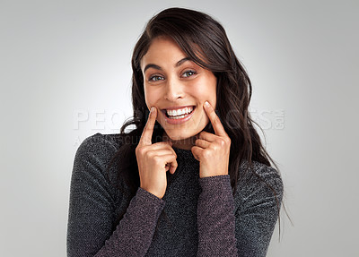 Buy stock photo Cropped shot of a beautiful young woman smiling against a grey background