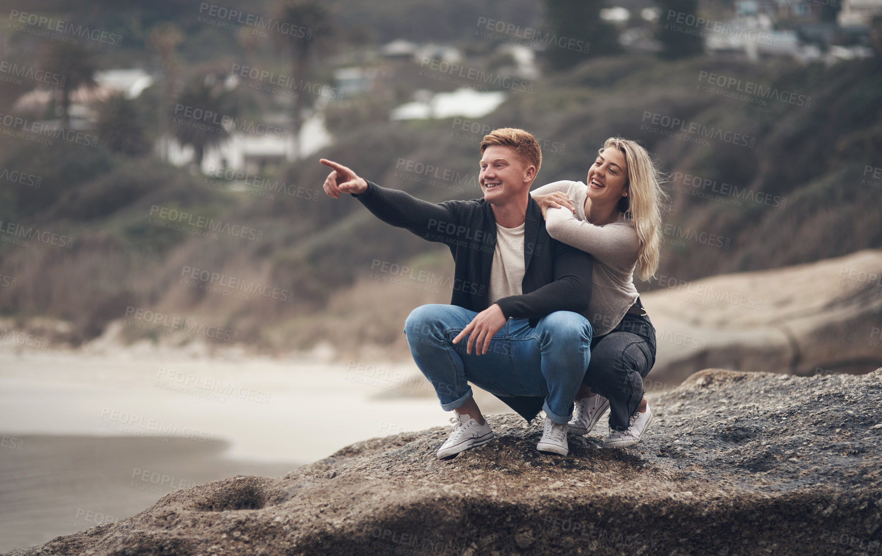 Buy stock photo Shot of a young couple spending the day together at the beach