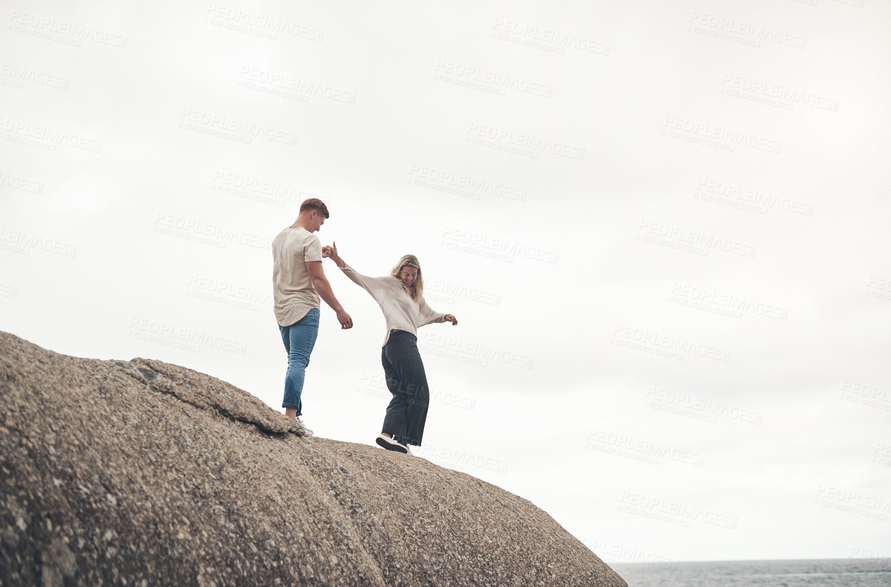 Buy stock photo Shot of a young couple spending the day together at the beach