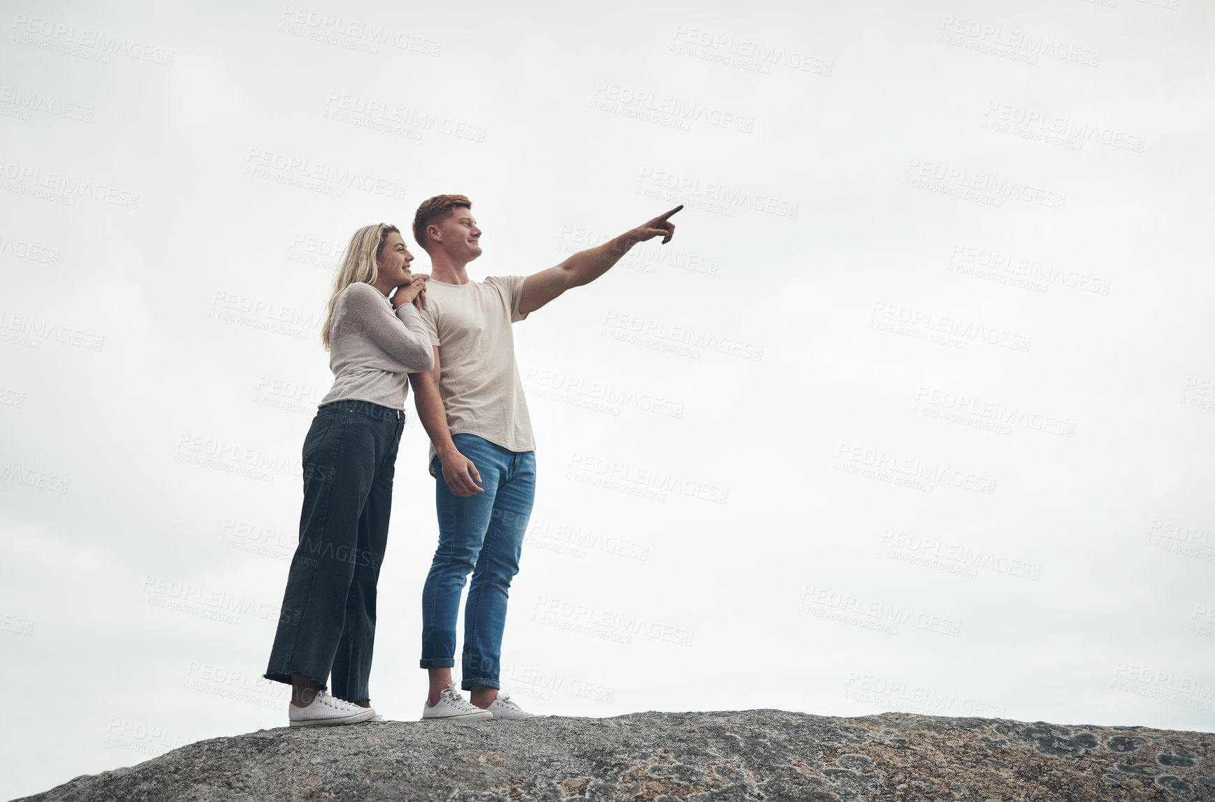 Buy stock photo Shot of a young couple spending the day together at the beach