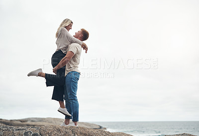 Buy stock photo Shot of a young couple spending the day together at the beach