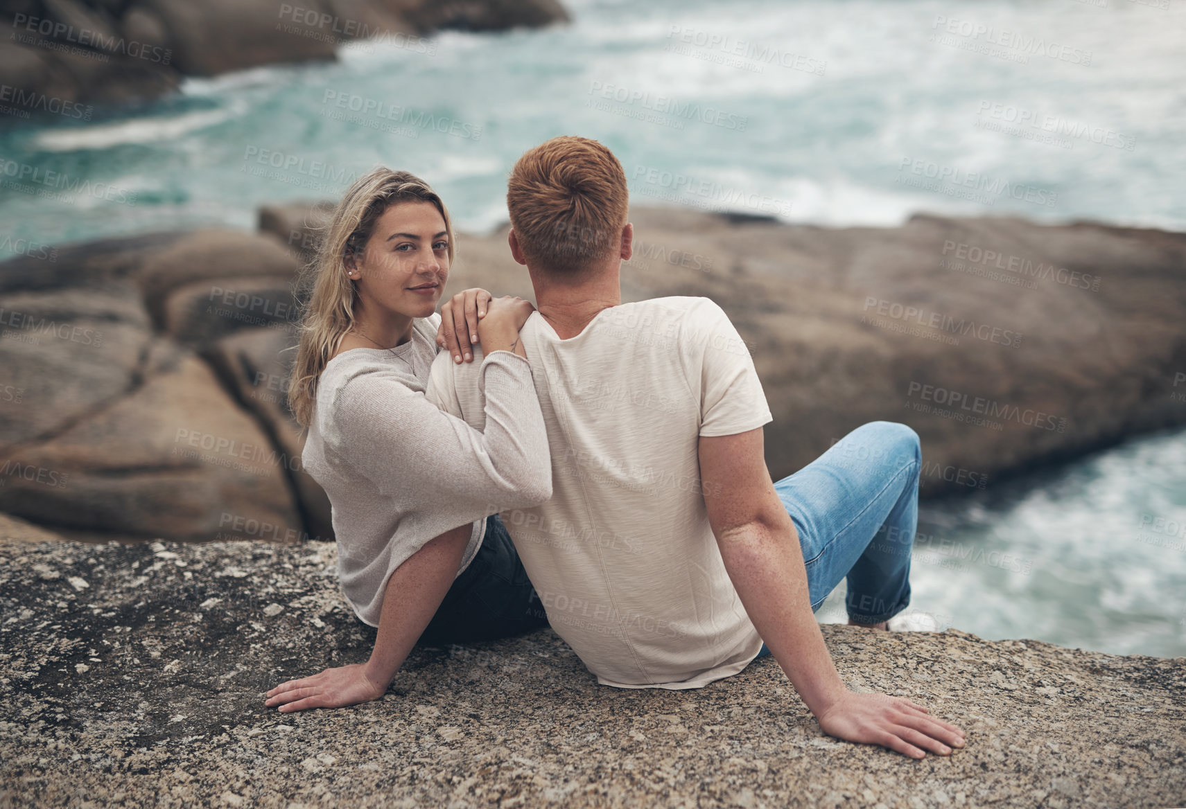 Buy stock photo Shot of a young couple spending the day together at the beach