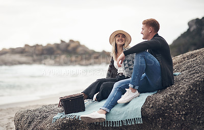 Buy stock photo Shot of a young couple spending the day together at the beach