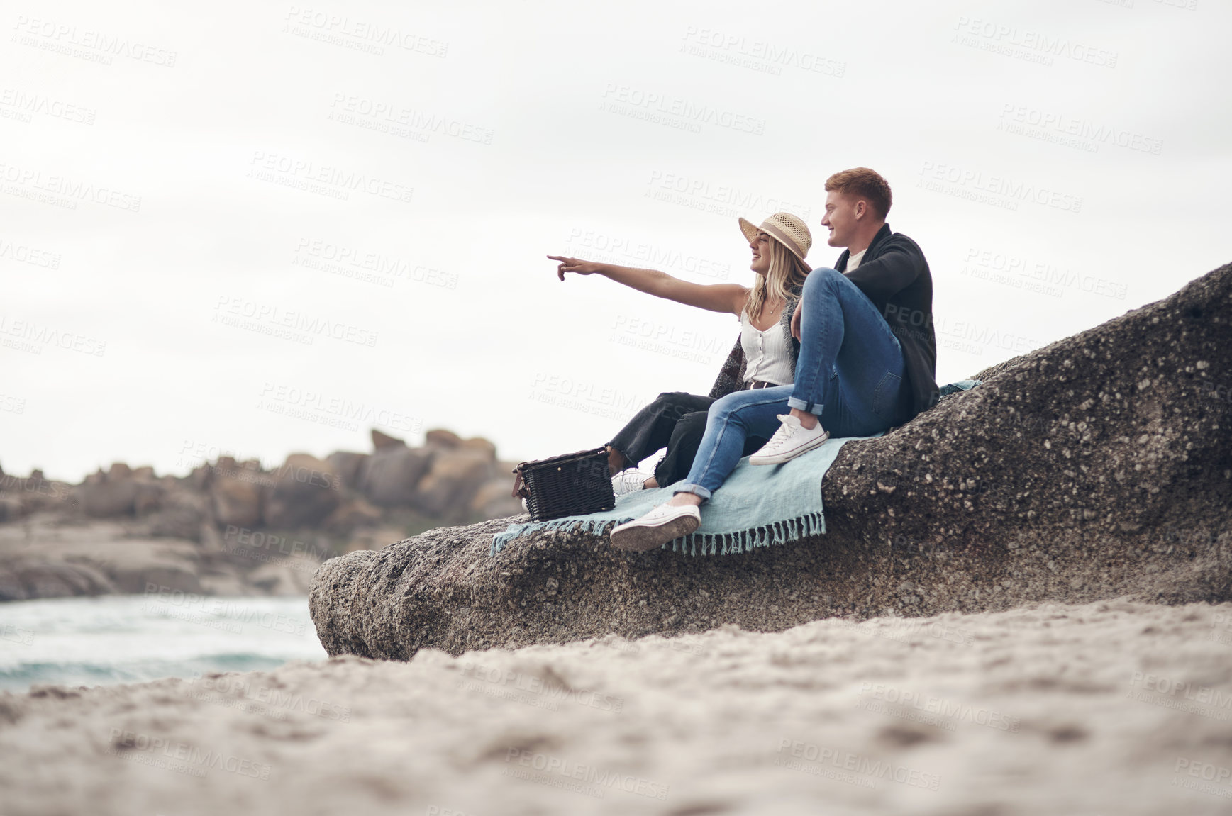 Buy stock photo Shot of a young couple spending the day together at the beach