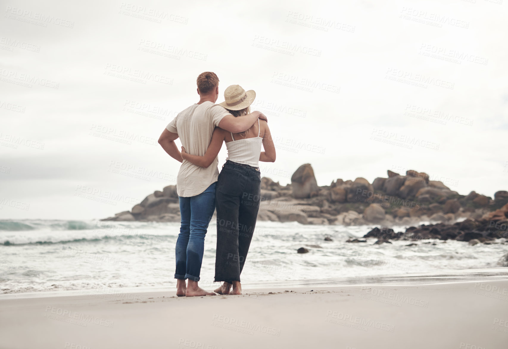 Buy stock photo Shot of a young couple spending the day together at the beach