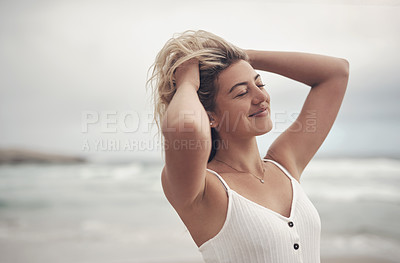 Buy stock photo Shot of a beautiful young woman spending the day at the beach