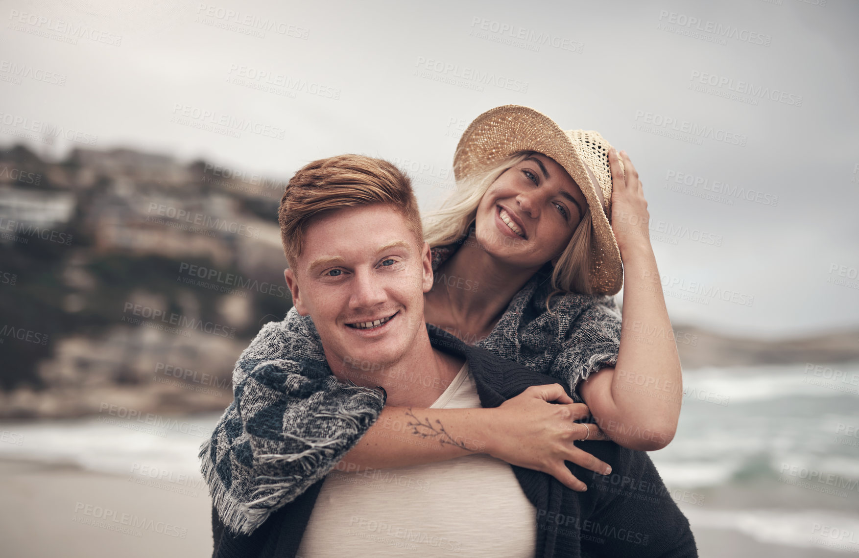 Buy stock photo Shot of a man piggybacking his girlfriend while walking on the beach