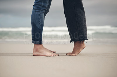 Buy stock photo Cropped shot of an unrecognisable couple standing barefoot on the beach