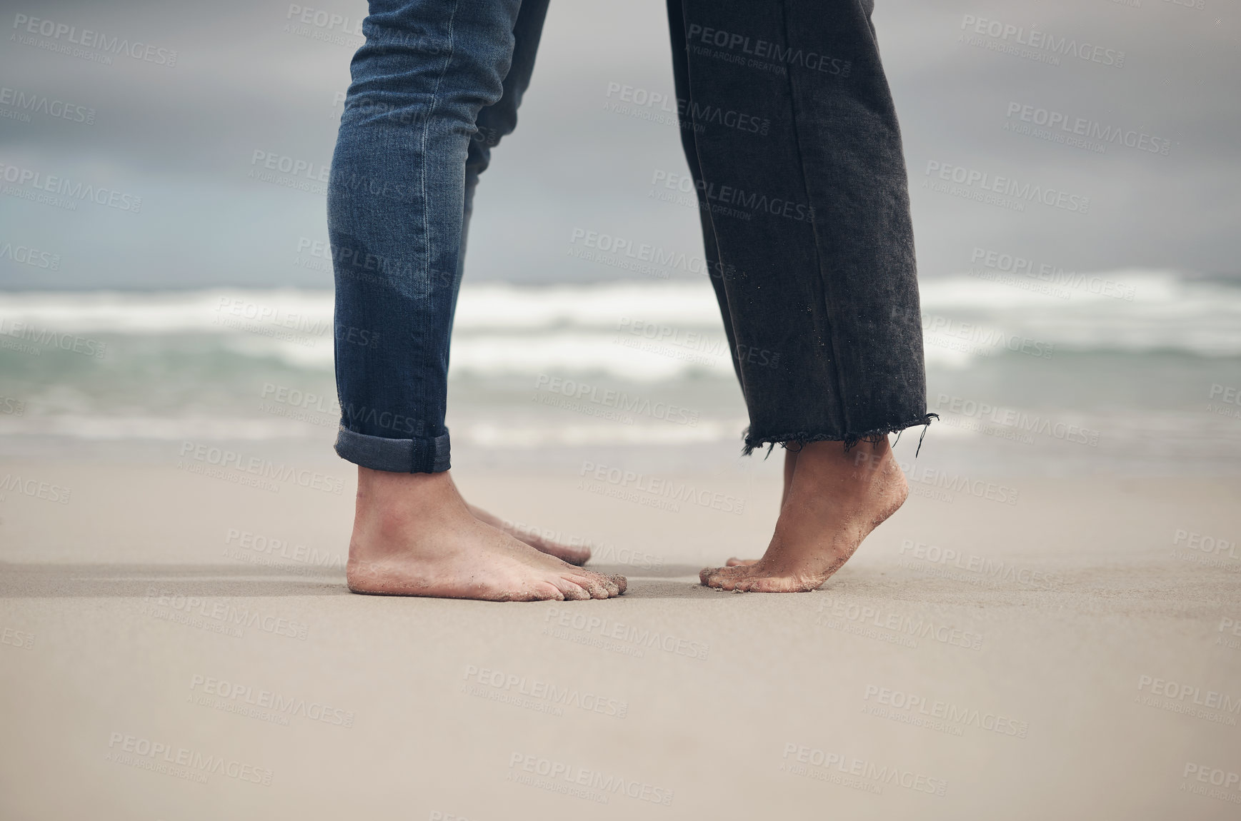 Buy stock photo Cropped shot of an unrecognisable couple standing barefoot on the beach