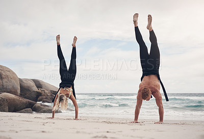 Buy stock photo Shot of a couple doing handstands on the beach