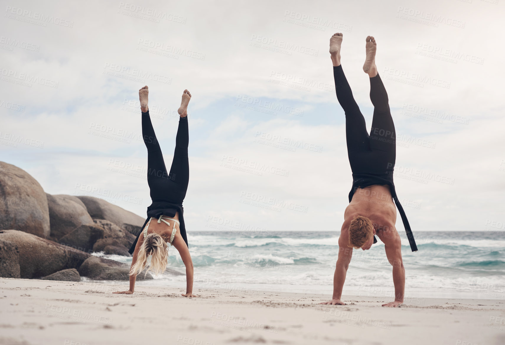 Buy stock photo Shot of a couple doing handstands on the beach