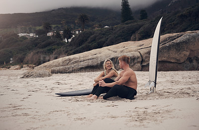 Buy stock photo Shot of a couple out at the beach with their surfboards