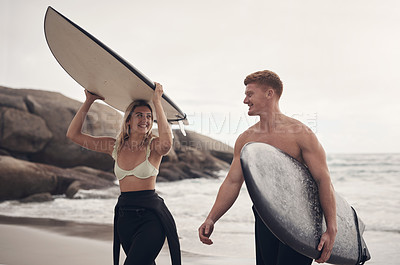 Buy stock photo Shot of a young couple out at the beach with their surfboards