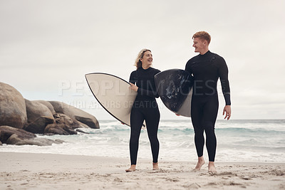 Buy stock photo Shot of a young couple out at the beach with their surfboards