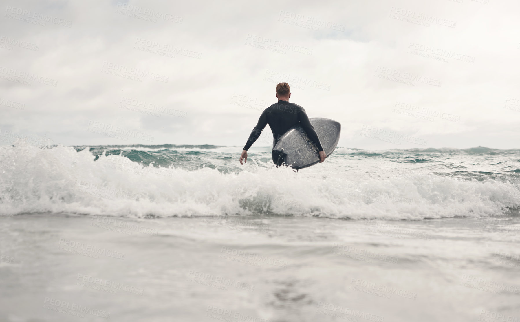 Buy stock photo Shot of a young man out surfing at the beach