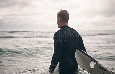 Buy stock photo Shot of a young man out surfing at the beach