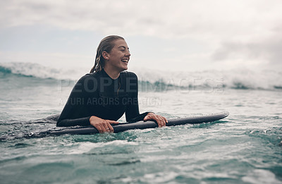 Buy stock photo Shot of a young woman out surfing at the beach