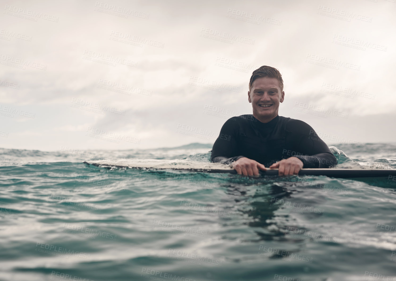 Buy stock photo Shot of a young man out surfing at the beach