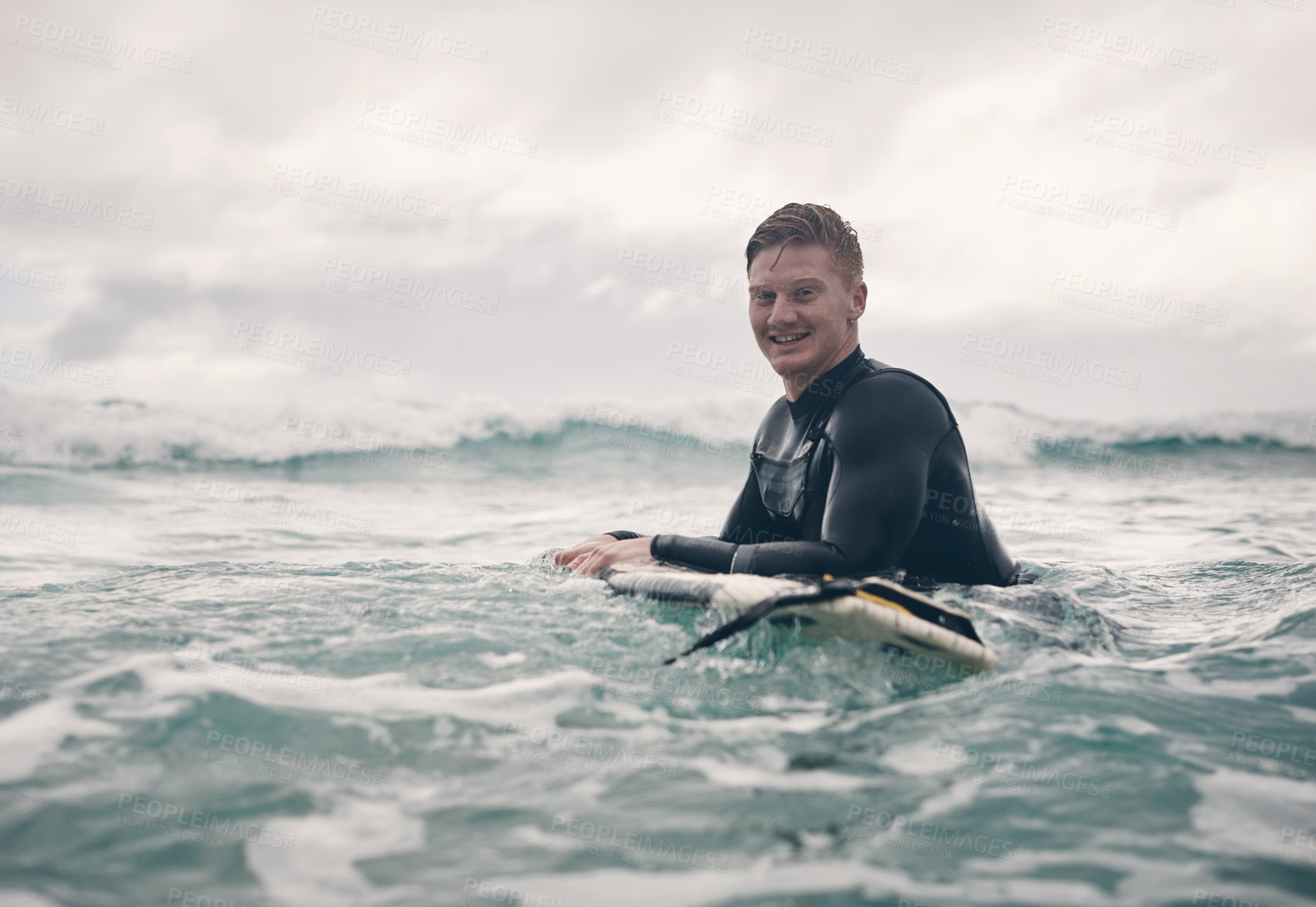 Buy stock photo Shot of a young man out surfing at the beach