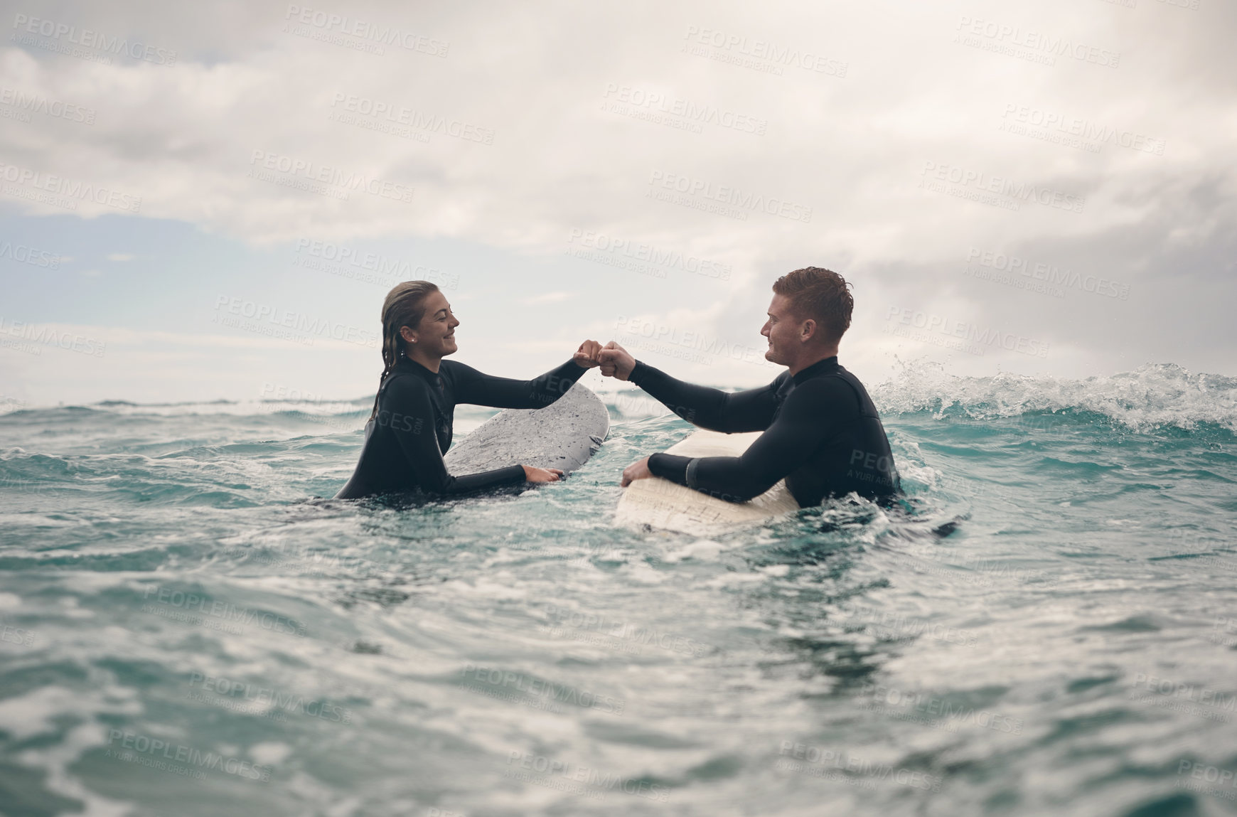 Buy stock photo Shot of a young couple out surfing together at the beach