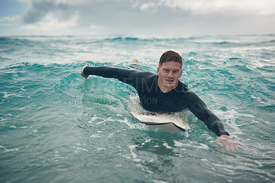 Buy stock photo Shot of a young man out surfing at the beach
