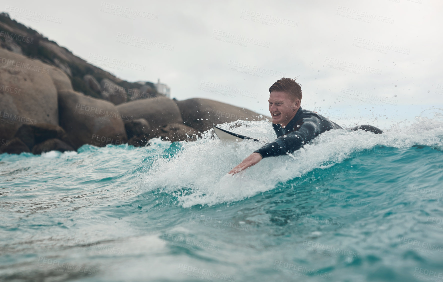 Buy stock photo Shot of a young man out surfing at the beach