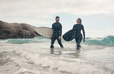 Buy stock photo Shot of a young couple out surfing together at the beach