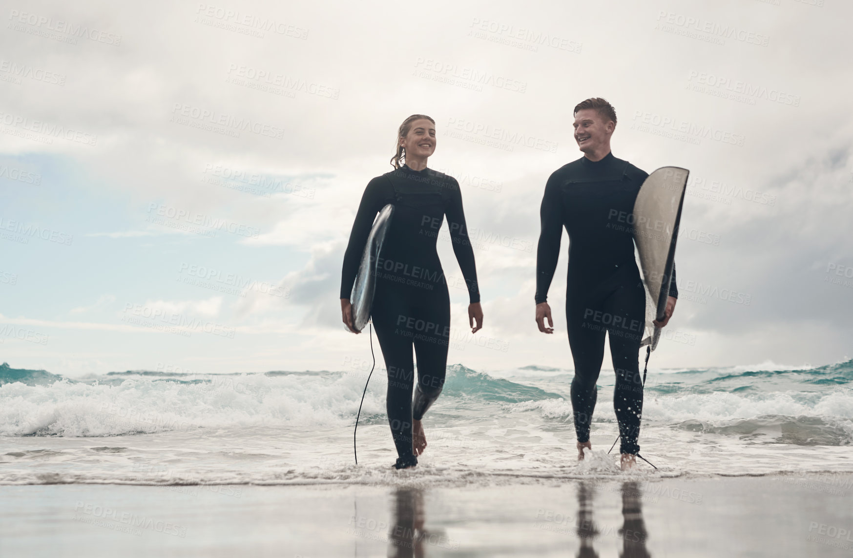 Buy stock photo Shot of a young couple out surfing together at the beach