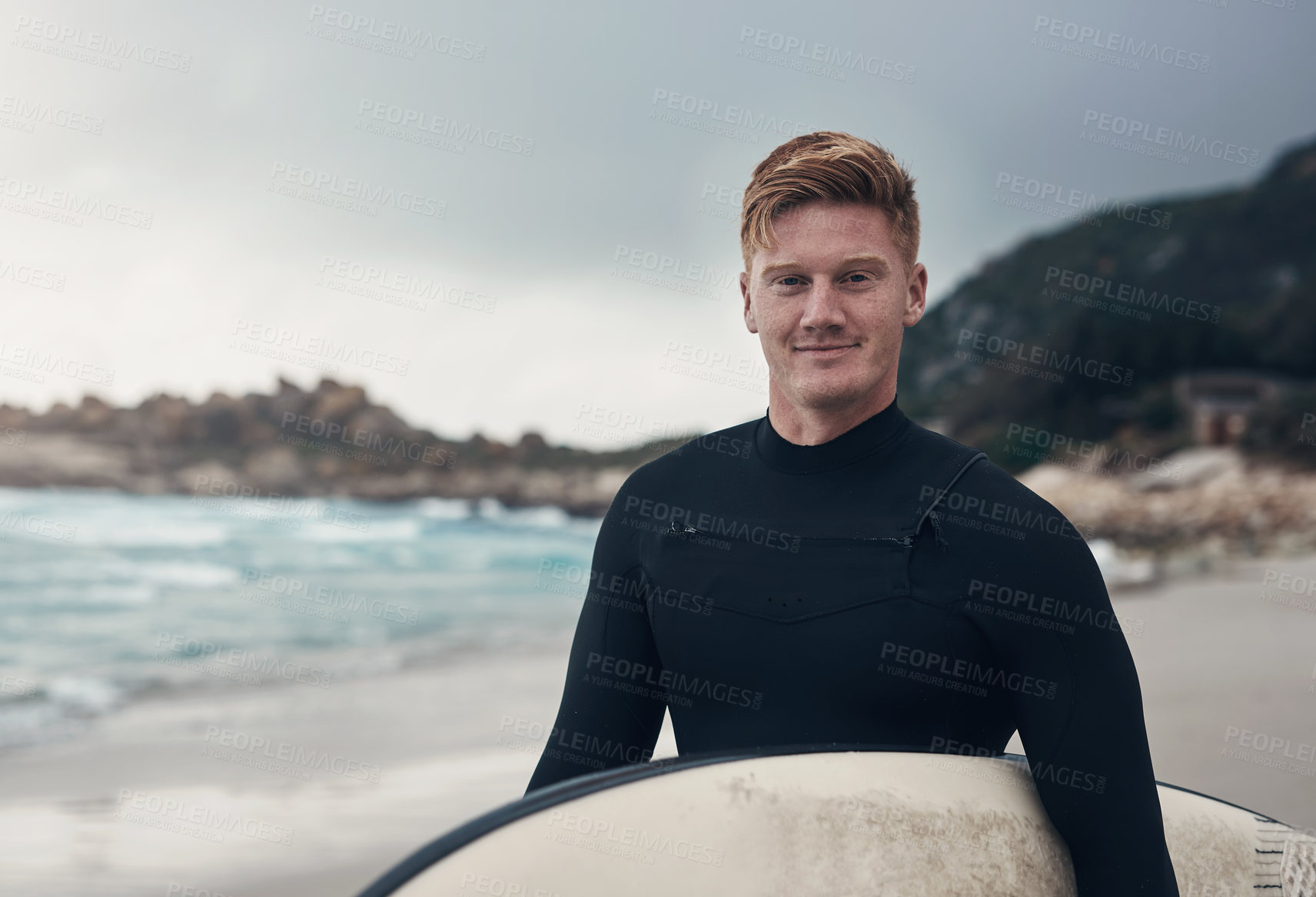 Buy stock photo Cropped shot of a man holding his surfboard while at the beach