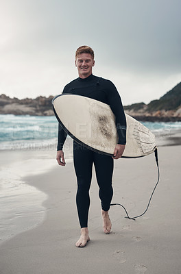 Buy stock photo Cropped shot of a man holding his surfboard while at the beach