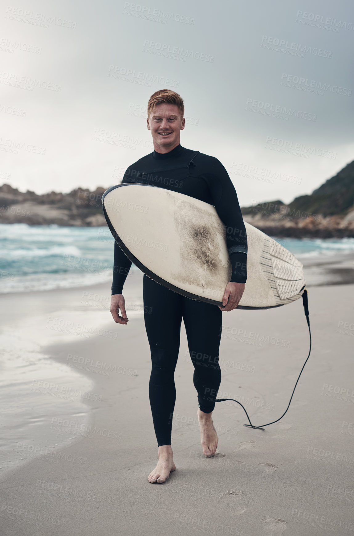 Buy stock photo Cropped shot of a man holding his surfboard while at the beach