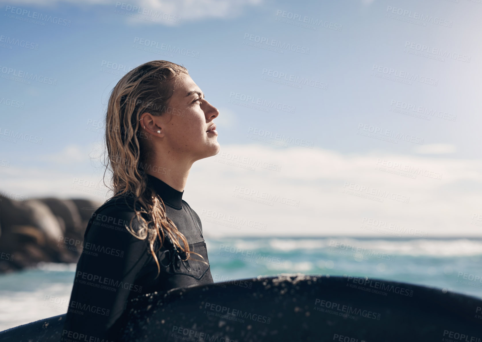 Buy stock photo Cropped shot of a young woman holding her surfboard while at the beach