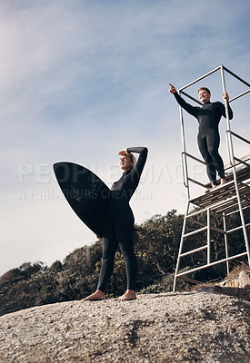Buy stock photo Shot of two people pointing at something while standing by a lifeguard tower