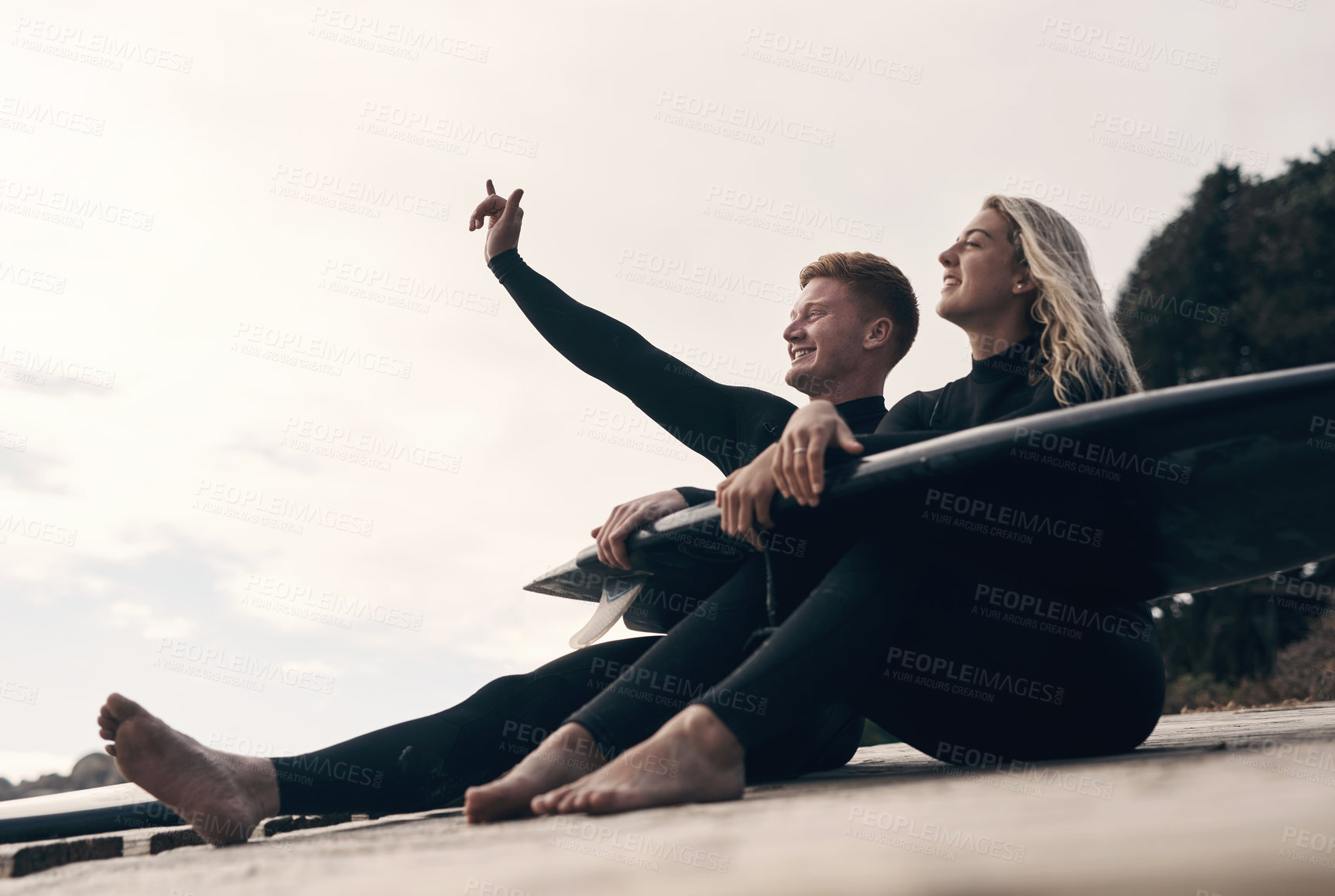 Buy stock photo Shot of a young couple out surfing together at the beach