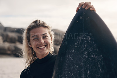 Buy stock photo Cropped shot of a young woman standing on the beach with her surfboard