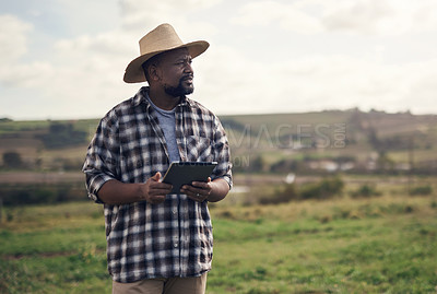 Buy stock photo Shot of a mature man using a digital tablet while working on a farm